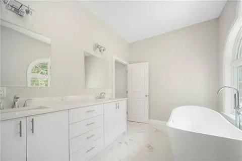 70 Shady Ln, Burrillville, RI 02859 - full bath featuring marble look tile flooring, double vanity, and a freestanding bath