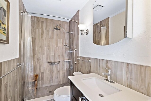 589 Depot St, Harwich, MA 02645 - full bathroom with a wainscoted wall, visible vents, a tile shower, toilet, and vanity
