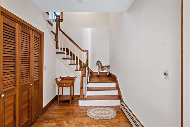 589 Depot St, Harwich, MA 02645 - stairway with baseboards, wood finished floors, and a baseboard radiator