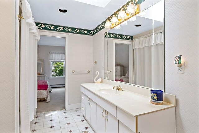589 Depot St, Harwich, MA 02645 - ensuite bathroom featuring vanity, baseboards, wallpapered walls, ensuite bath, and a baseboard radiator