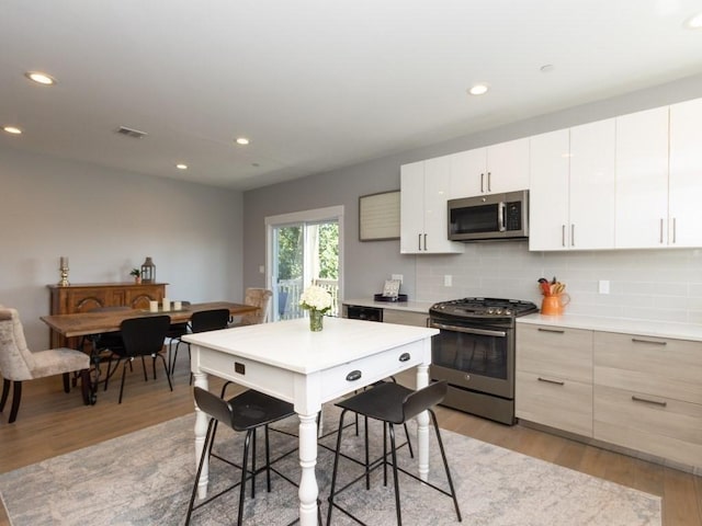 447 Frankfort St Unit 3, Boston, MA 02128 - kitchen featuring appliances with stainless steel finishes, light wood-style floors, decorative backsplash, and recessed lighting