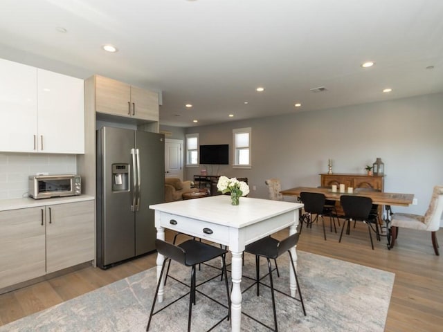 447 Frankfort St Unit 3, Boston, MA 02128 - kitchen with stainless steel fridge with ice dispenser, light wood-style floors, recessed lighting, tasteful backsplash, and modern cabinets