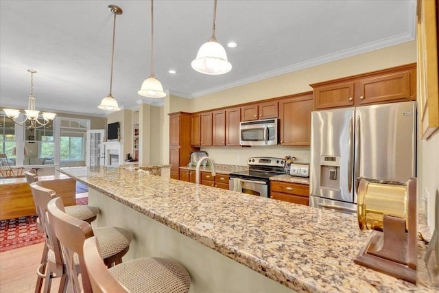 17 Chadwick Ct Unit 17, Mashpee, MA 02649 - kitchen featuring appliances with stainless steel finishes, brown cabinets, crown molding, light wood finished floors, and a breakfast bar area