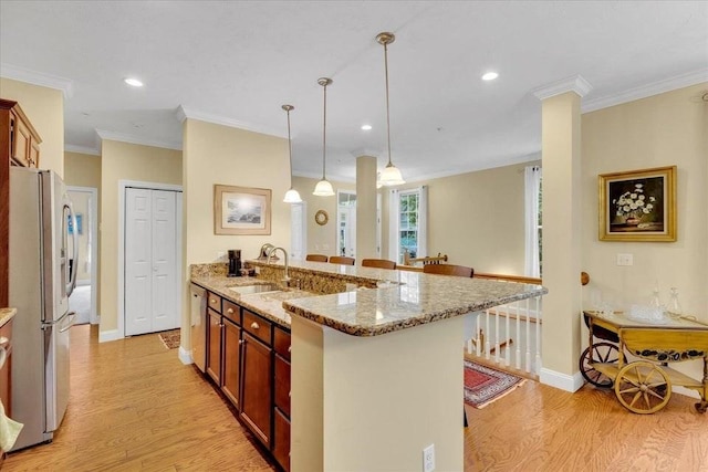 17 Chadwick Ct Unit 17, Mashpee, MA 02649 - kitchen with freestanding refrigerator, light wood-type flooring, light stone counters, a kitchen breakfast bar, and crown molding