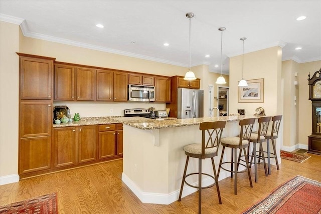 17 Chadwick Ct Unit 17, Mashpee, MA 02649 - kitchen featuring appliances with stainless steel finishes, light wood-style floors, brown cabinets, a kitchen bar, and light stone counters