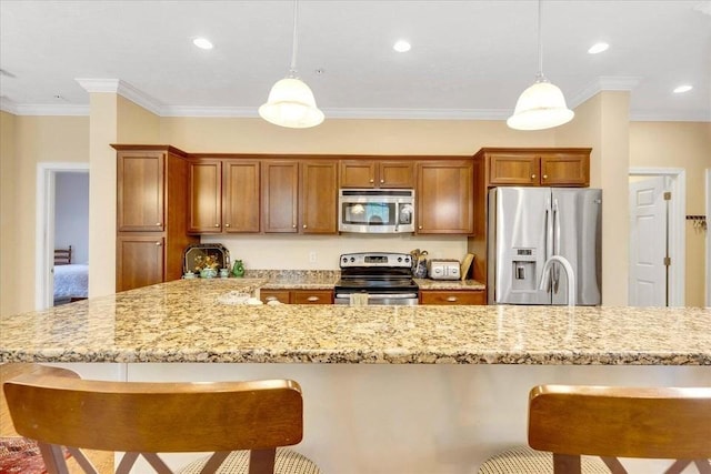 17 Chadwick Ct Unit 17, Mashpee, MA 02649 - kitchen featuring stainless steel appliances, a kitchen bar, brown cabinets, ornamental molding, and recessed lighting