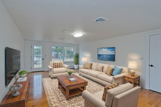 living room featuring visible vents and light wood-style flooring