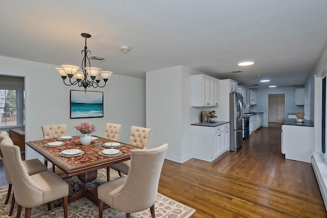 dining space with dark wood-style flooring, a notable chandelier, a baseboard radiator, recessed lighting, and visible vents