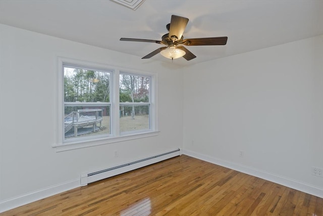 spare room with a baseboard heating unit, ceiling fan, hardwood / wood-style floors, and baseboards