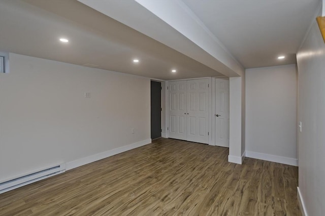 finished basement with a baseboard radiator, baseboards, wood finished floors, and recessed lighting