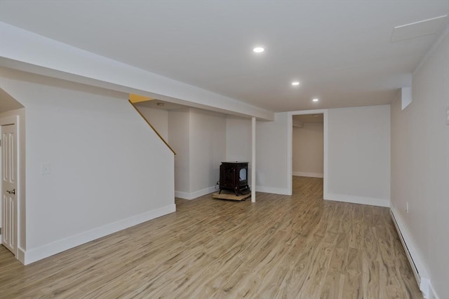 finished below grade area with light wood-type flooring, baseboards, and recessed lighting