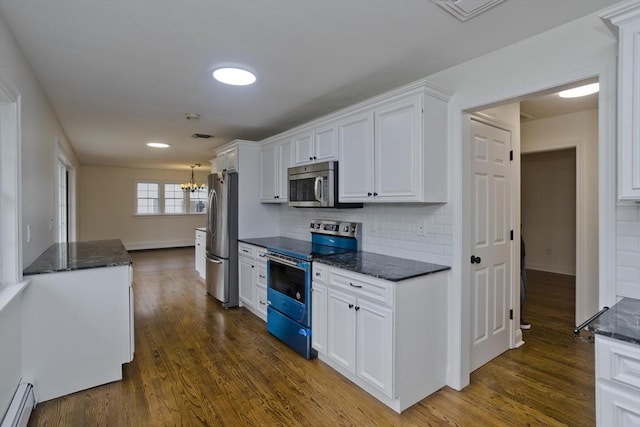 kitchen featuring appliances with stainless steel finishes, dark wood-style flooring, a baseboard heating unit, and white cabinetry