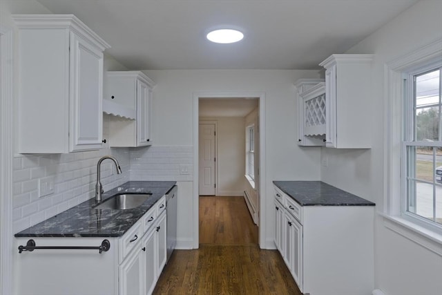 kitchen featuring a sink, white cabinets, stainless steel dishwasher, dark stone countertops, and dark wood finished floors