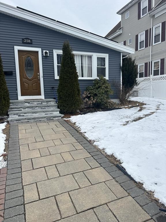 snow covered property entrance featuring fence