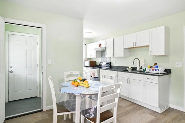 80-82 Kenyon St, Springfield, MA 01109 - kitchen with electric stove, a sink, light wood-style floors, white cabinetry, and dark countertops