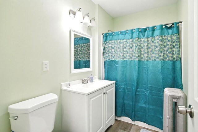 80-82 Kenyon St, Springfield, MA 01109 - full bathroom featuring toilet, wood finished floors, vanity, radiator heating unit, and a shower with curtain
