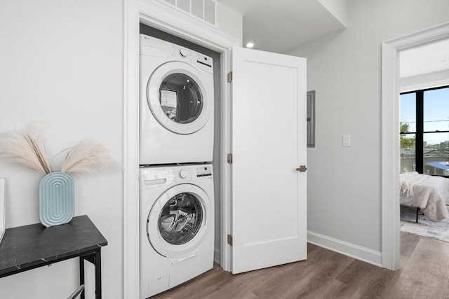 523 2nd St Unit 303, Everett, MA 02149 - laundry room with stacked washer / drying machine, wood finished floors, and baseboards
