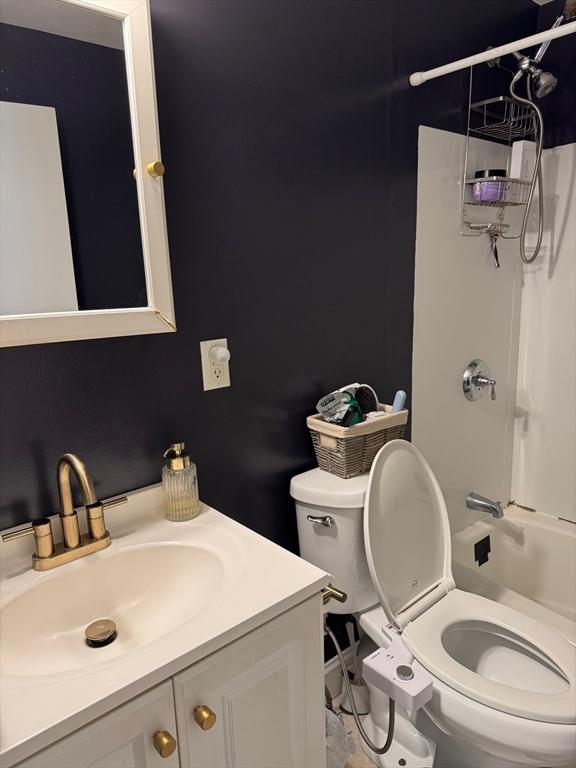 full bath featuring bathtub / shower combination, vanity, and toilet