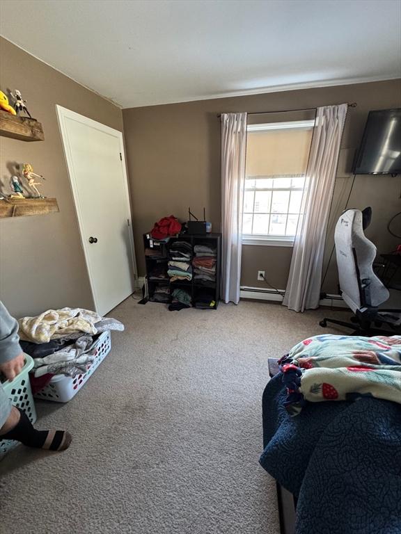 bedroom featuring a baseboard heating unit and carpet flooring