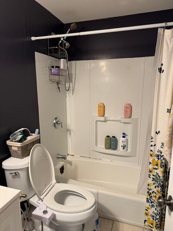 bathroom featuring shower / bath combo with shower curtain, vanity, toilet, and tile patterned floors