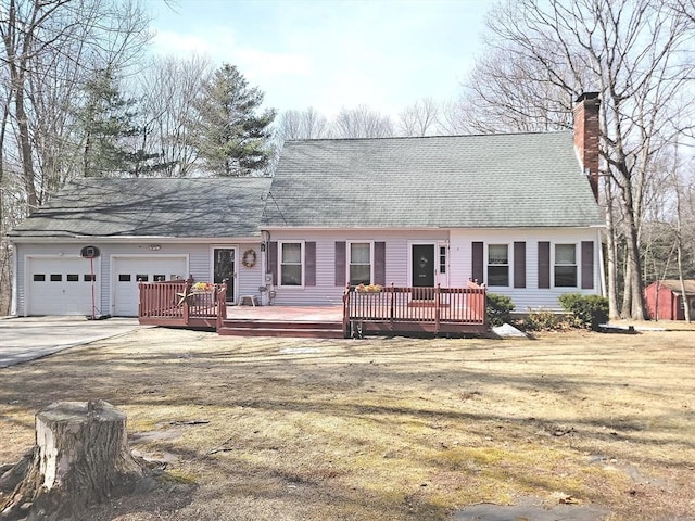 view of front of house with a chimney, a garage, driveway, and a wooden deck