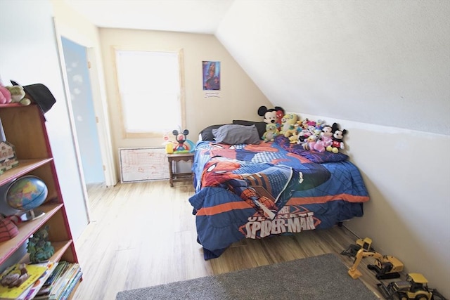 bedroom with lofted ceiling and wood finished floors