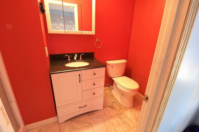 bathroom featuring baseboards, toilet, and vanity