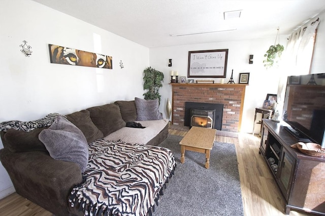 living room featuring a brick fireplace and wood finished floors