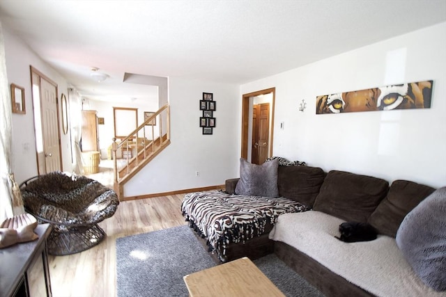 living area with stairway, wood finished floors, and baseboards