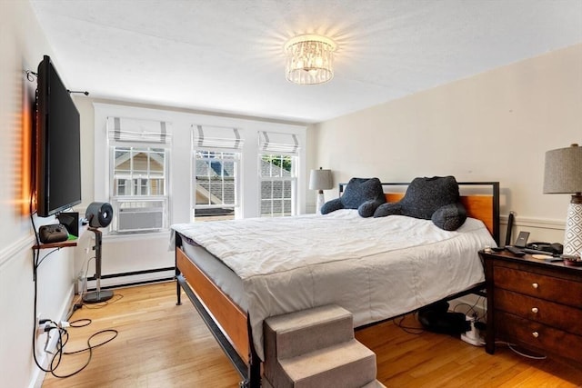 2218 Mystic Valley Pkwy, Medford, MA 02155 - bedroom featuring light wood-style flooring, baseboard heating, cooling unit, and a chandelier