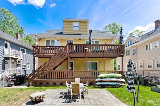 2218 Mystic Valley Pkwy, Medford, MA 02155 - rear view of house with an outdoor fire pit, a wooden deck, a patio area, and a lawn