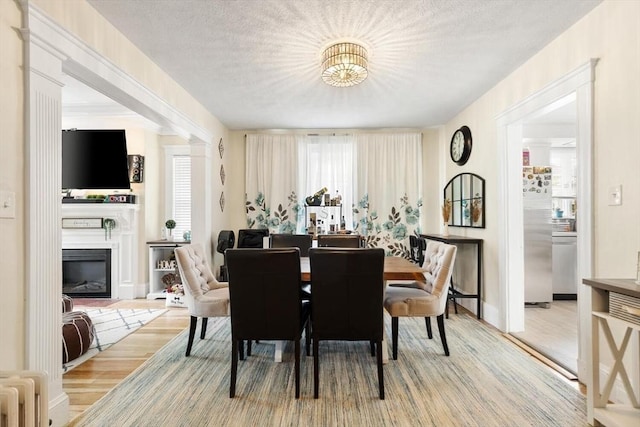 2218 Mystic Valley Pkwy, Medford, MA 02155 - dining space featuring wood finished floors, a glass covered fireplace, and baseboards