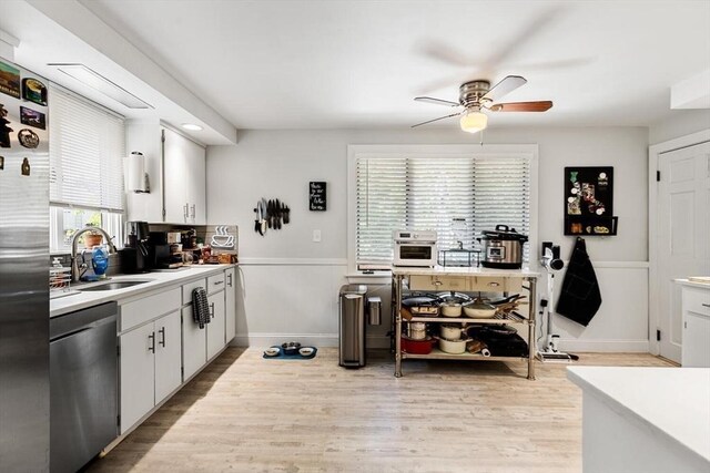 2218 Mystic Valley Pkwy, Medford, MA 02155 - kitchen with appliances with stainless steel finishes, a sink, light wood-style floors, a ceiling fan, and light countertops