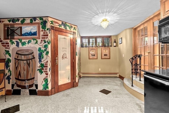 196 Plymouth Ave, Quincy, MA 02169 - detailed view of a baseboard heating unit, baseboards, black microwave, french doors, and speckled floor