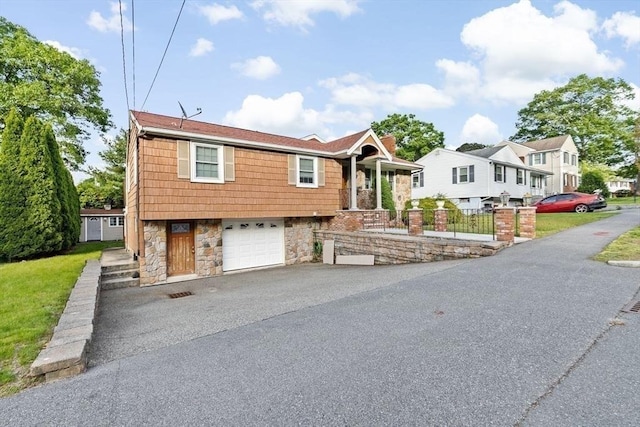 196 Plymouth Ave, Quincy, MA 02169 - view of front facade with stone siding, an attached garage, asphalt driveway, and a residential view