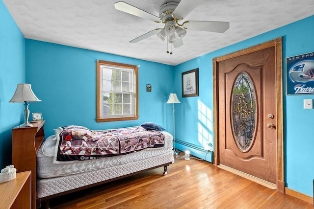 196 Plymouth Ave, Quincy, MA 02169 - bedroom with a baseboard radiator, baseboards, wood finished floors, and a ceiling fan