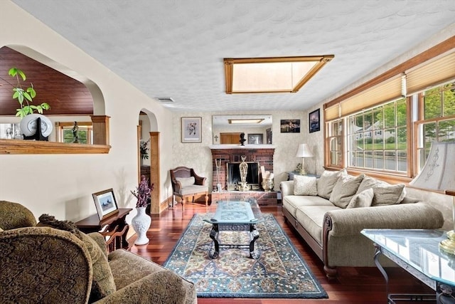 196 Plymouth Ave, Quincy, MA 02169 - living area featuring arched walkways, dark wood-type flooring, a fireplace, and a textured ceiling