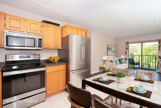 kitchen with dark countertops, stainless steel appliances, open floor plan, and decorative backsplash