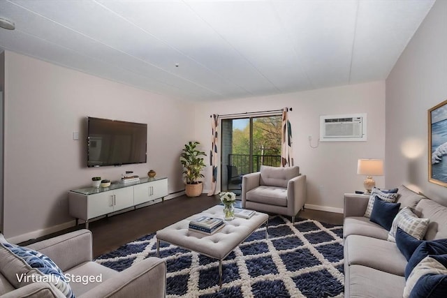 living area with an AC wall unit, baseboards, and wood finished floors