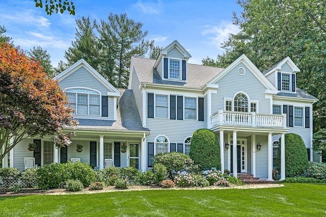 view of front of home with a porch, a front yard, roof with shingles, and a balcony