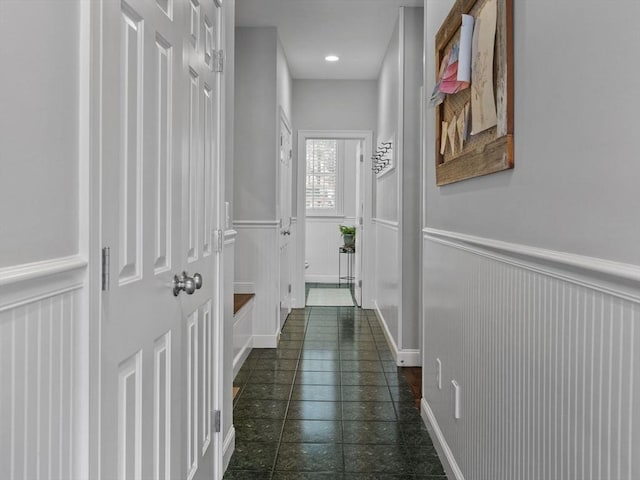 hallway with a wainscoted wall and recessed lighting