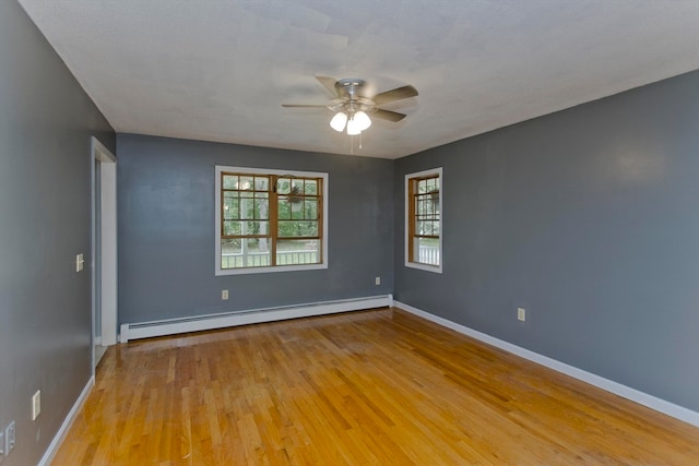 spare room featuring ceiling fan, a baseboard radiator, and light hardwood / wood-style flooring