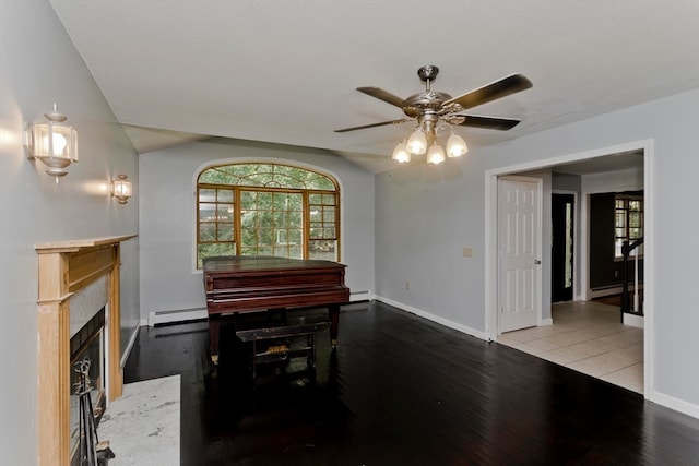 dining space with ceiling fan, a baseboard radiator, a premium fireplace, and light hardwood / wood-style floors