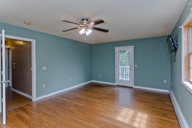 spare room with ceiling fan, light hardwood / wood-style flooring, and a baseboard heating unit