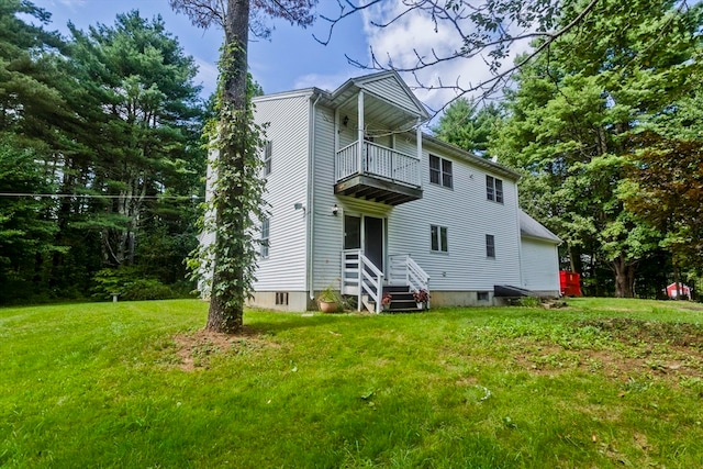 back of property with a balcony and a yard