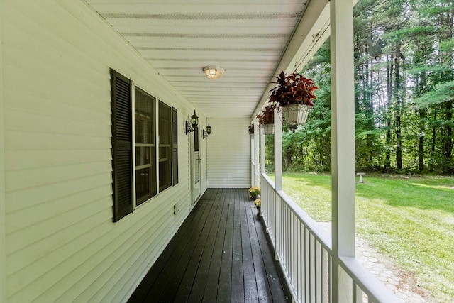 wooden terrace featuring covered porch and a yard