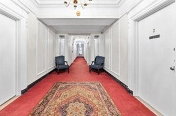 hallway featuring dark carpet