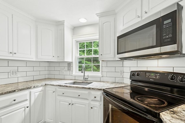 31 Granite St, Walpole, MA 02081 - kitchen featuring black range with electric cooktop, stainless steel microwave, white cabinetry, and decorative backsplash