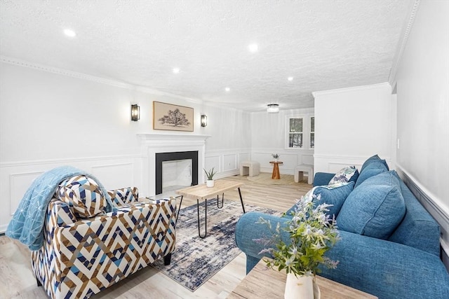 living room featuring crown molding, a textured ceiling, and light wood-type flooring