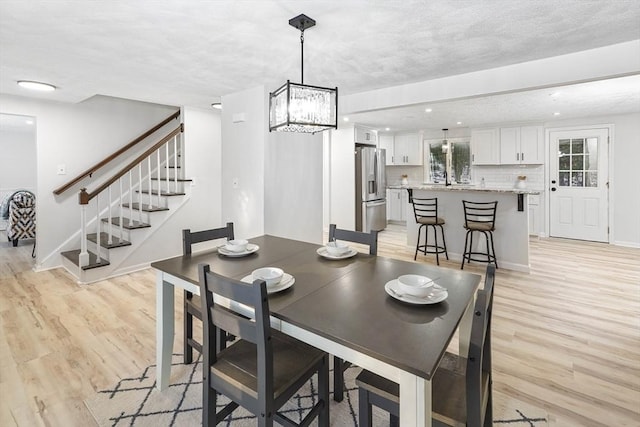 dining space featuring a notable chandelier and light hardwood / wood-style floors